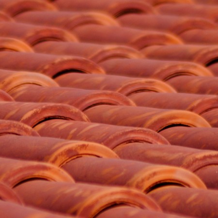 Rows of interlocking orange clay barrel roof tiles on a residential roof
