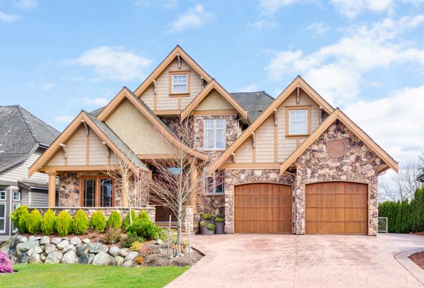 Two-story suburban house with stone siding and brown roof shingles in Pleasanton CA