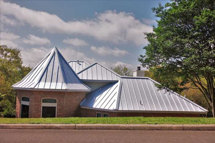 Commercial Metal Roof Installation in Pittsburg Brick commercial building featuring a silver standing seam metal roof installation in Pittsburg